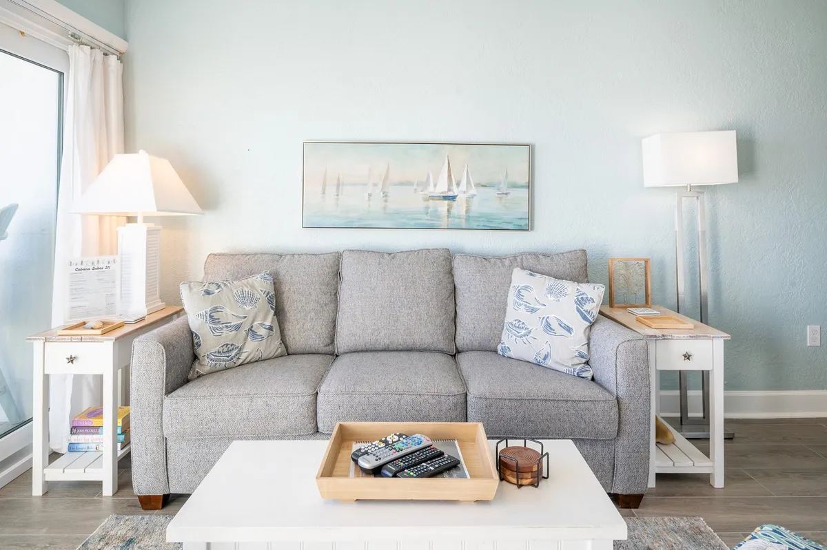 A serene interior scene highlighting a comfortable sofa, elegant side tables, and inviting lamps, with tasteful artwork on the walls. The space is organized for relaxation and socializing, suggesting inviting moments spent lounging with loved ones.